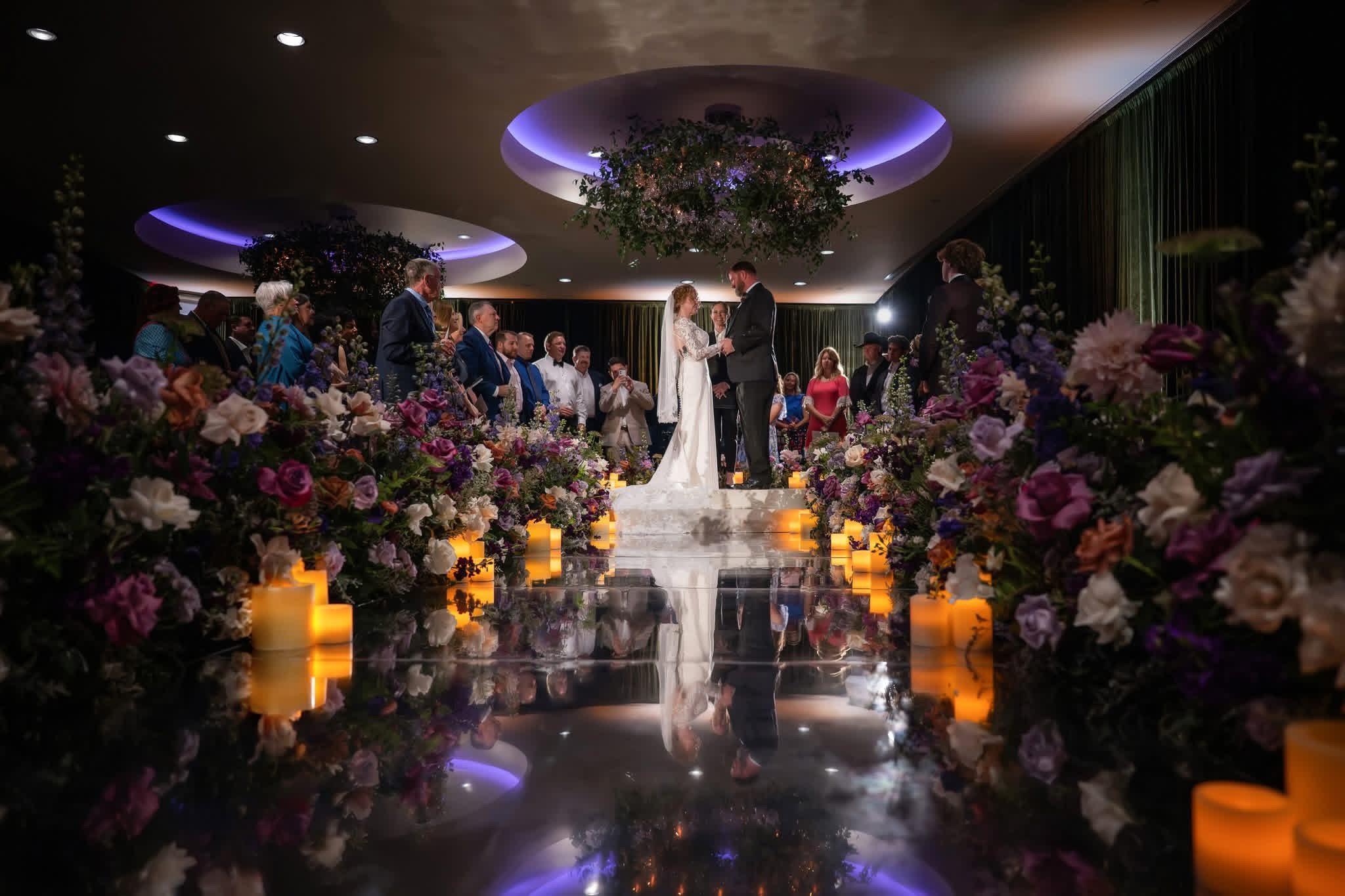 A candlelit wedding ceremony surrounded by rich floral arrangements